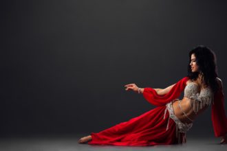 Woman in red arabic dress dancing oriental dances in stalls
