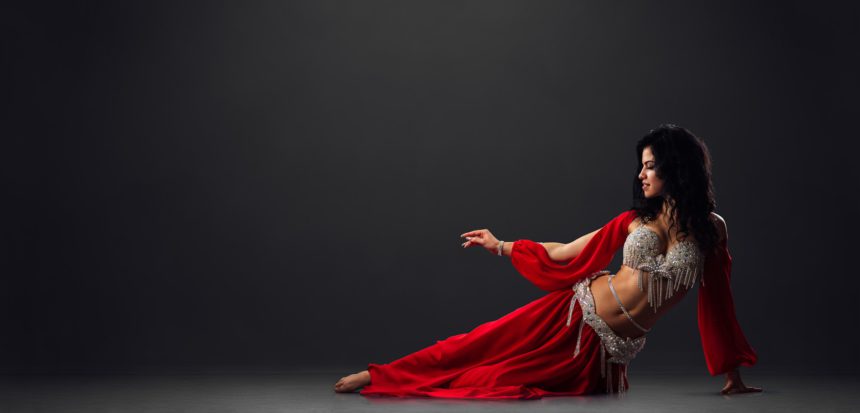 Woman in red arabic dress dancing oriental dances in stalls